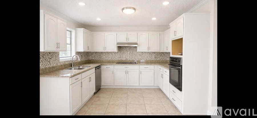 A kitchen with white cabinets and appliances.
