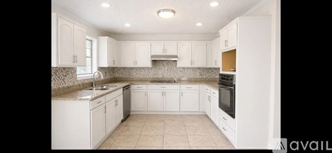 A kitchen with white cabinets and appliances.