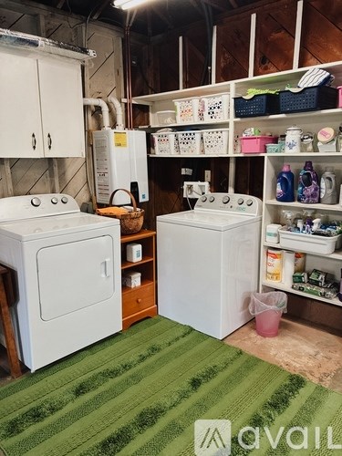 A kitchen with a white stove and oven, a white fridge, and a green rug.