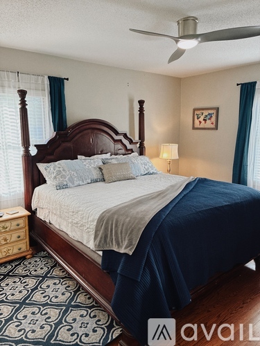 A bedroom with a bed, nightstand, and a ceiling fan.