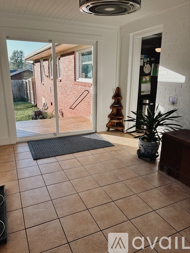 A living room with a tiled floor and a ceiling fan.