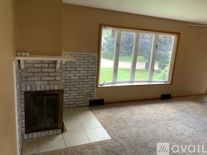 A living room with a fireplace and a large window.