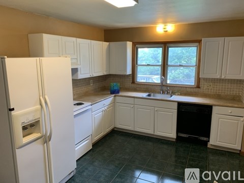 A kitchen with white cabinets and a white refrigerator.