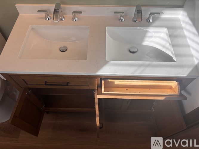 A bathroom with two sinks and a wooden cabinet underneath.