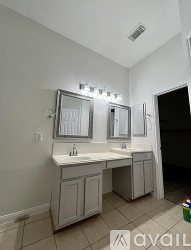A bathroom with a vanity and a mirror above it.