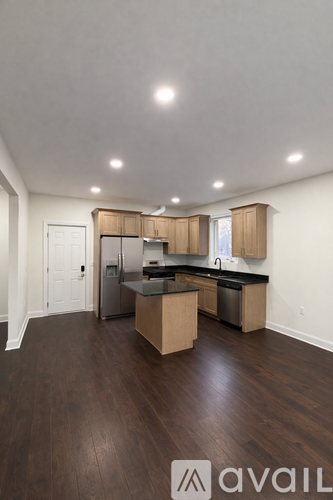 A kitchen with wooden cabinets and a black countertop.