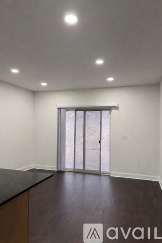 A room with a sliding door and wooden floors.