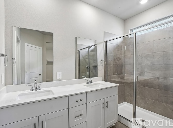 A bathroom with a white sink and a large mirror.