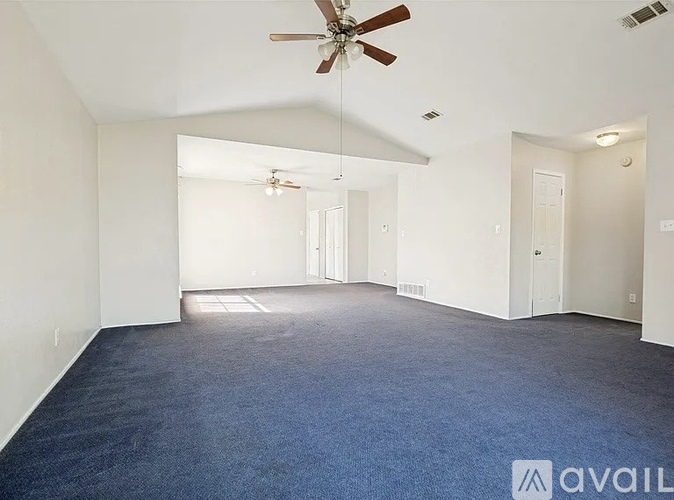 A spacious room with wooden flooring and a flat-screen TV mounted on the wall.