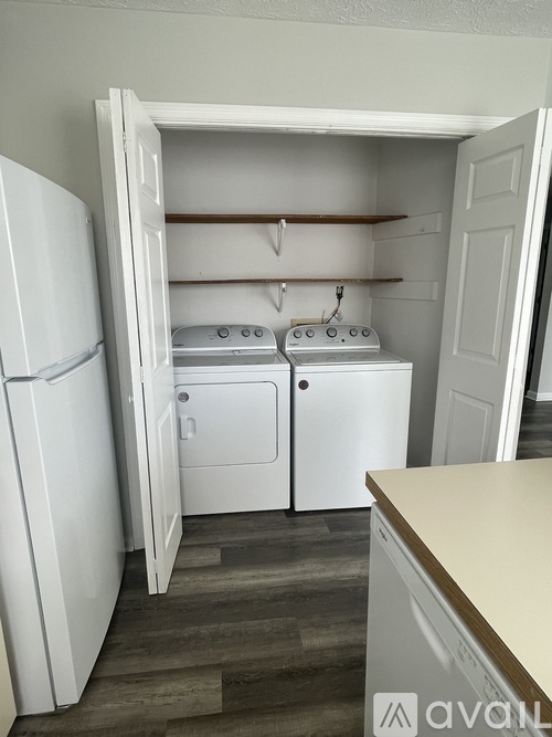 A small kitchen with a refrigerator, oven, and washing machine.