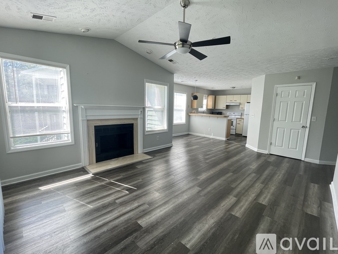 A spacious living room with a fireplace and hardwood floors.