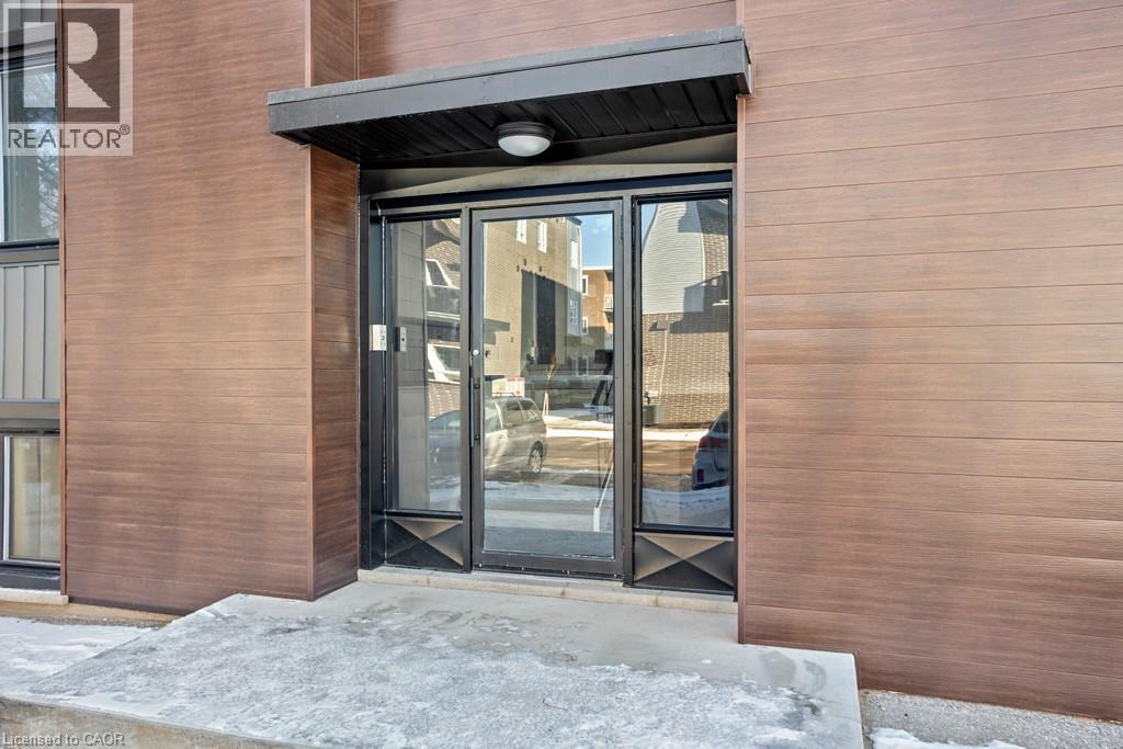 A building entrance with a glass door and a brown wall.