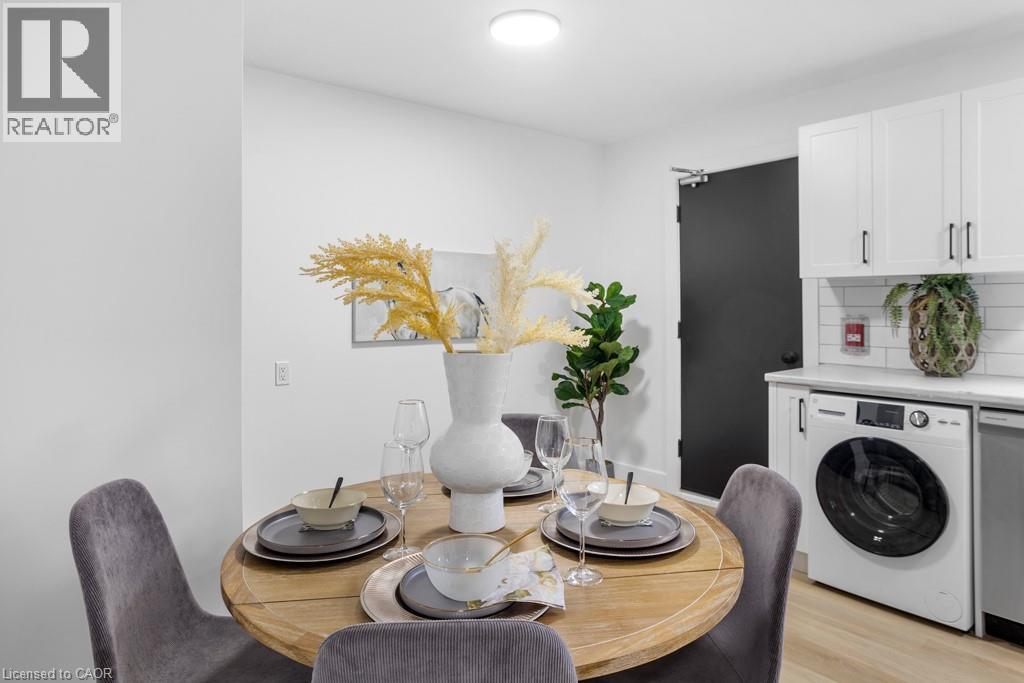 A dining room with a table set for two and a washing machine in the background.