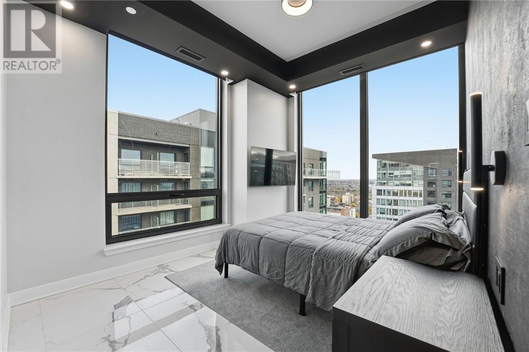 A bedroom with a large bed and a view of the city.