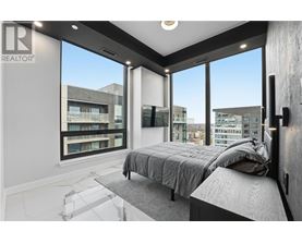 A bedroom with a large bed and a view of the city.