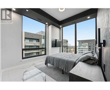 A bedroom with a large bed and a view of the city.