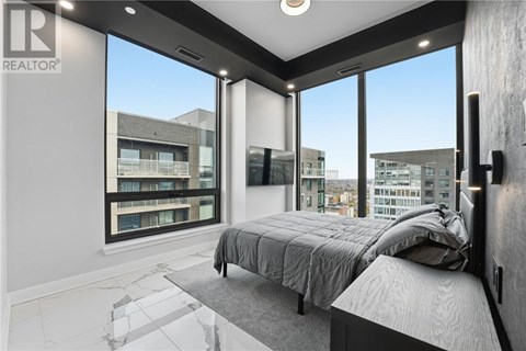 A bedroom with a large bed and a view of the city.