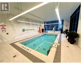 A large indoor pool with a caution no diving sign on the wall.