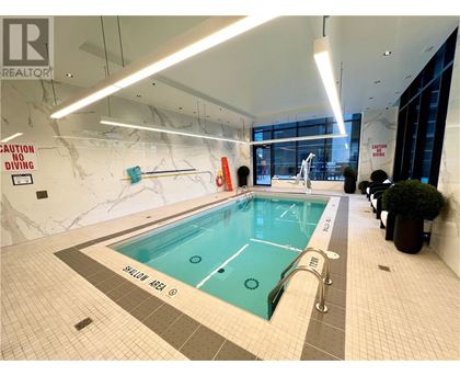 A large indoor pool with a caution no diving sign on the wall.
