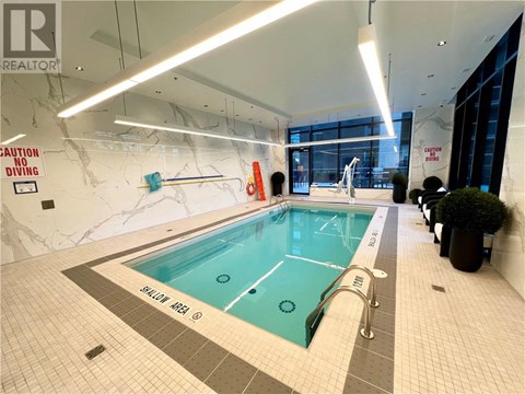 A large indoor pool with a caution no diving sign on the wall.