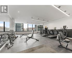 A gym with a variety of equipment including weights and benches.