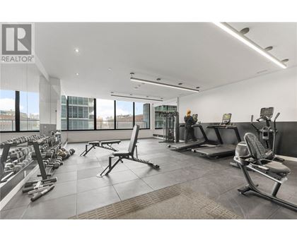 A gym with a variety of equipment including weights and benches.