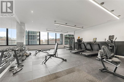 A gym with a variety of equipment including weights and benches.