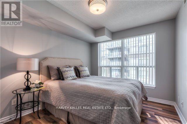 A bedroom with a bed, a lamp, and a window.