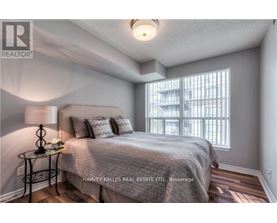 A bedroom with a bed, a lamp, and a window.
