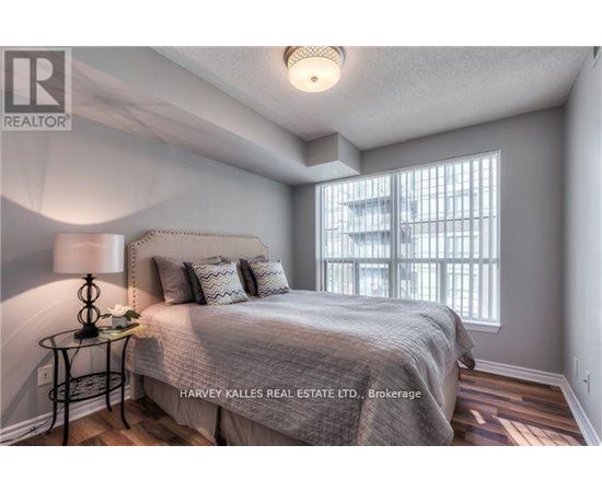 A bedroom with a bed, a lamp, and a window.