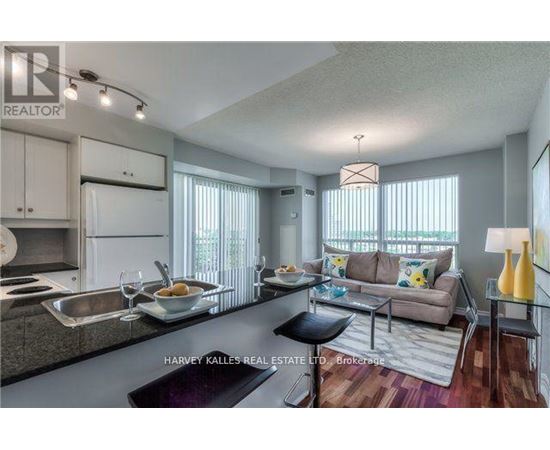A modern kitchen and living room with a dining table set for two.