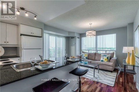 A modern kitchen and living room with a dining table set for two.