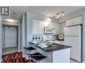A kitchen with a refrigerator, microwave, and stove top oven.