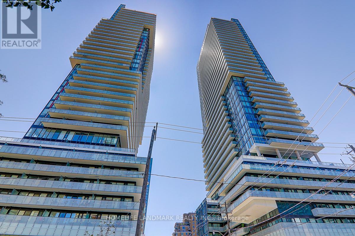 Two tall buildings with blue glass windows and a clear sky in the background.