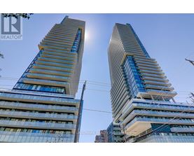 Two tall buildings with blue glass windows and a clear sky in the background.