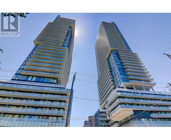 Two tall buildings with blue glass windows and a clear sky in the background.