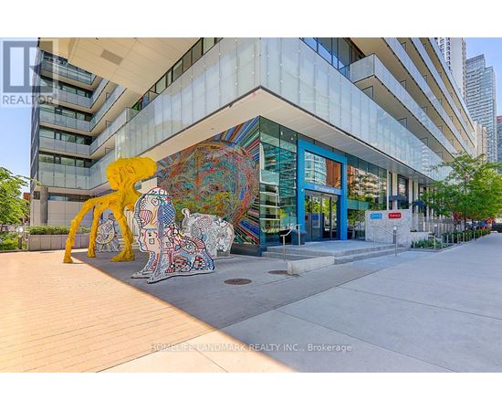 A large, colorful mural of a human figure is displayed in front of a modern building.