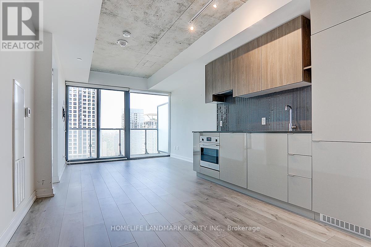 A spacious kitchen with white cabinets and a large window.