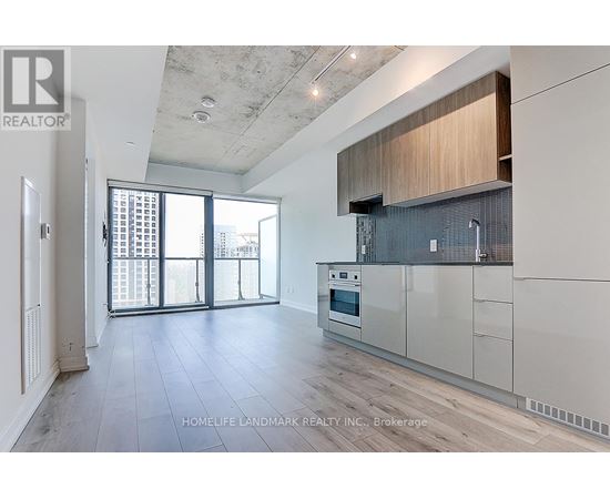 A spacious kitchen with white cabinets and a large window.