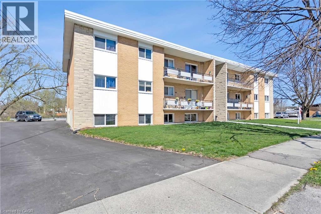 A large apartment building with a parking lot in front.