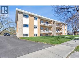 A large apartment building with a parking lot in front.