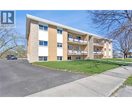A large apartment building with a parking lot in front.