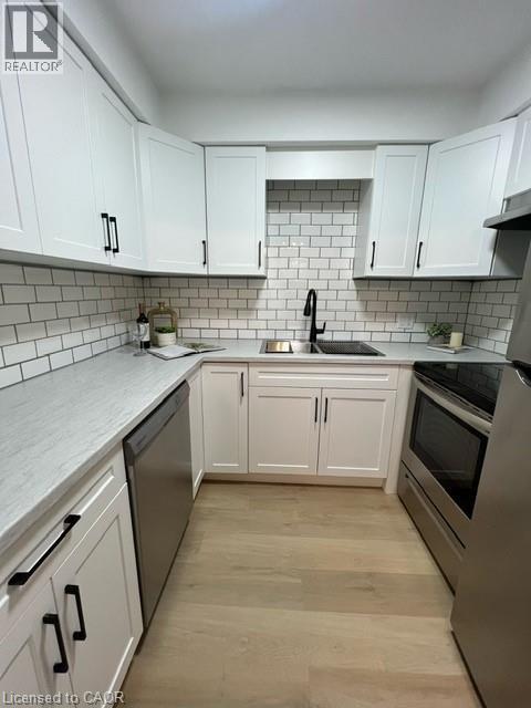 A kitchen with white cabinets and a black stove top oven.