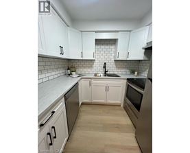 A kitchen with white cabinets and a black stove top oven.
