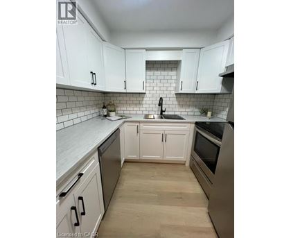 A kitchen with white cabinets and a black stove top oven.