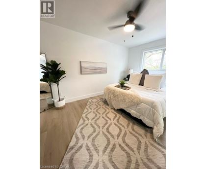 A bedroom with a large bed and a ceiling fan.