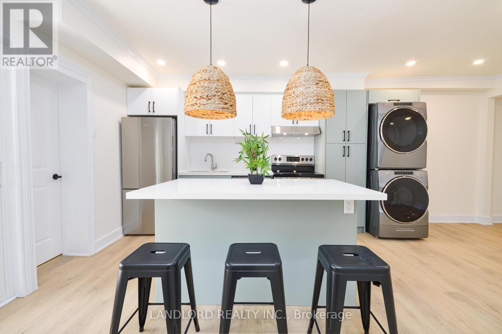 A kitchen with a white island and black stools.
