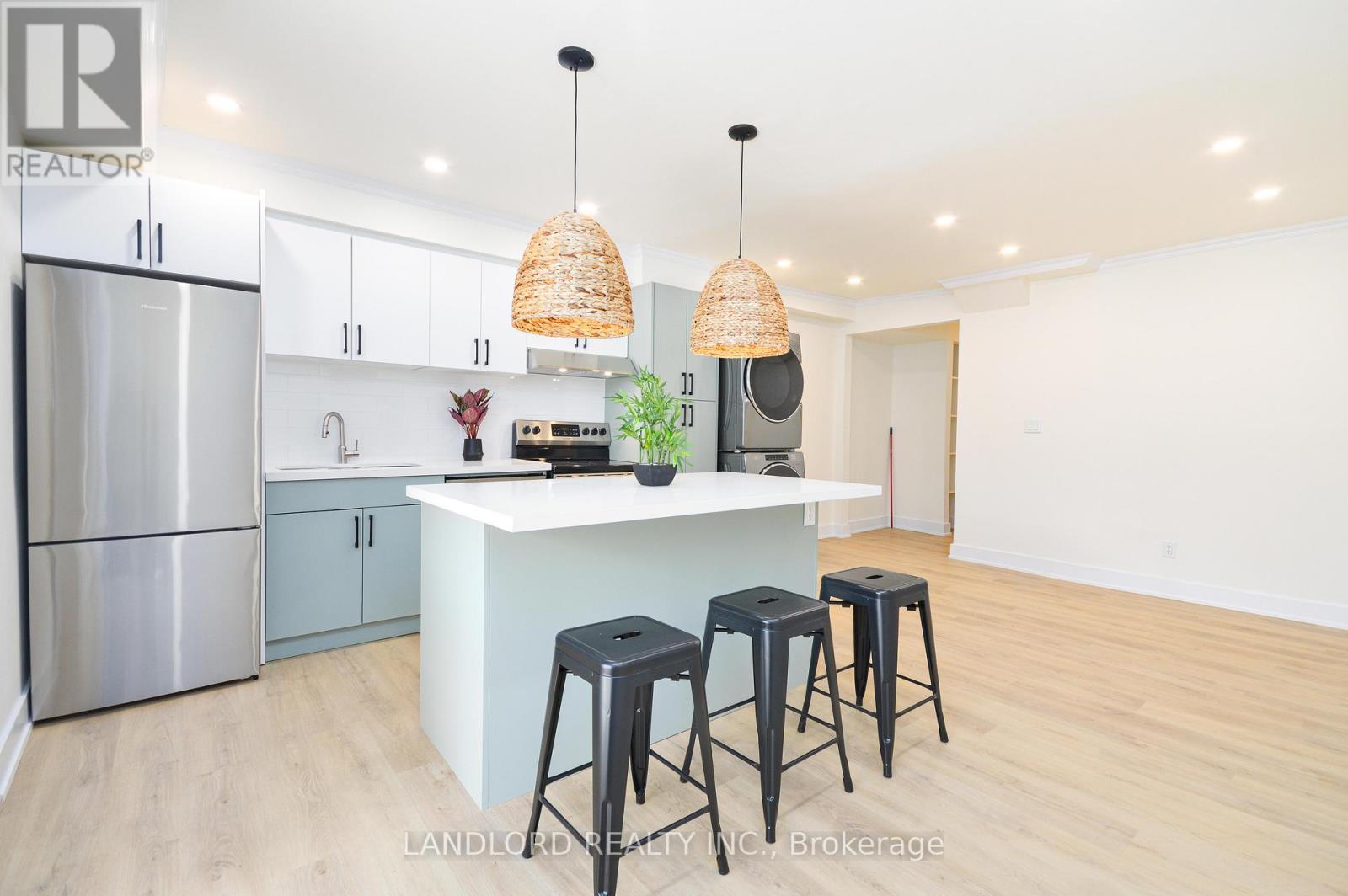 A kitchen with a white countertop and bar stools.