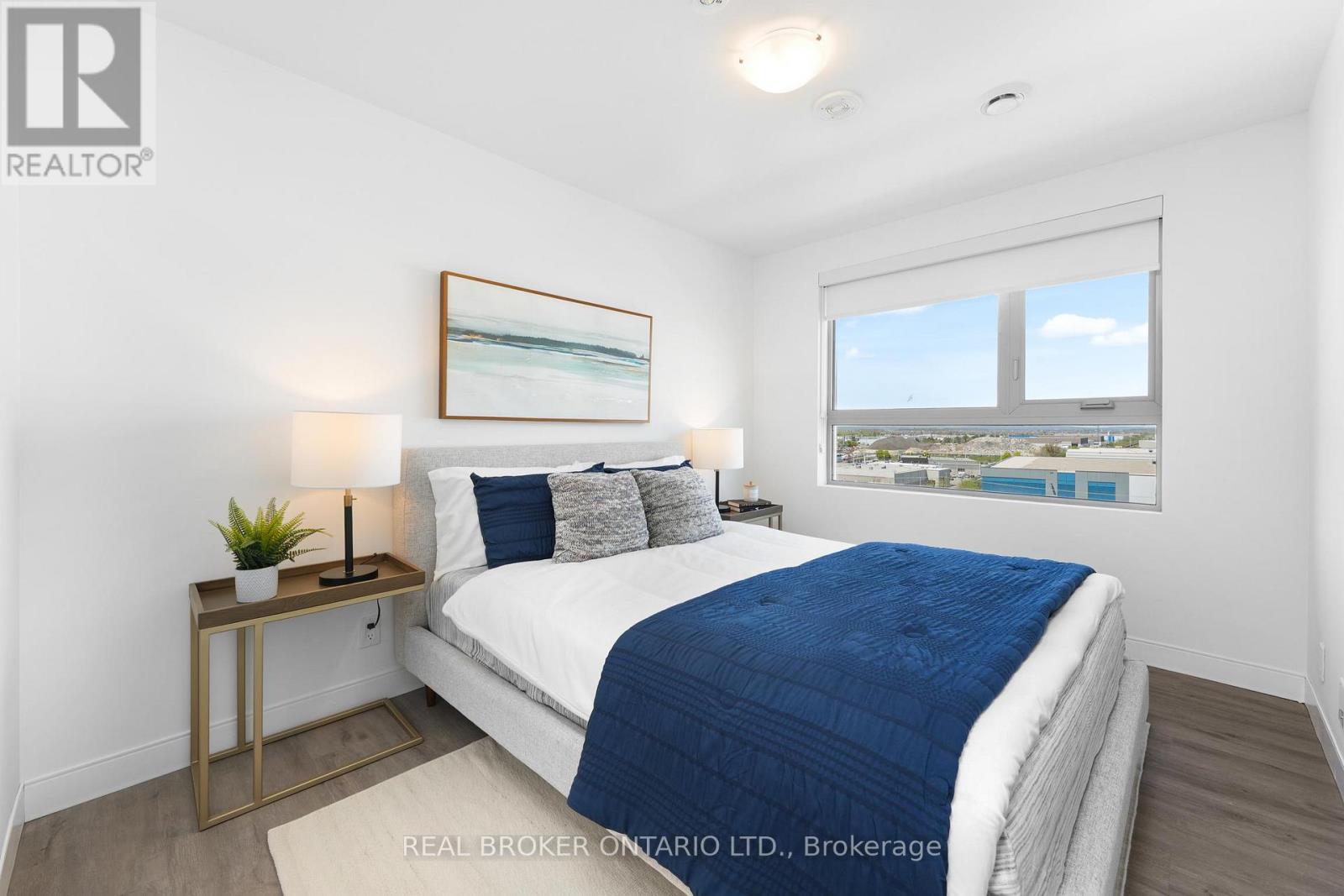 A bedroom with a bed, nightstand, and window.