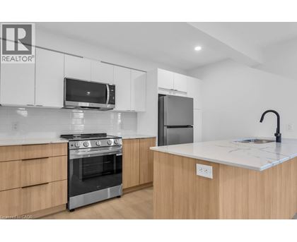 A modern kitchen with wooden cabinets and stainless steel appliances.